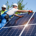 solar panel installers on a roof